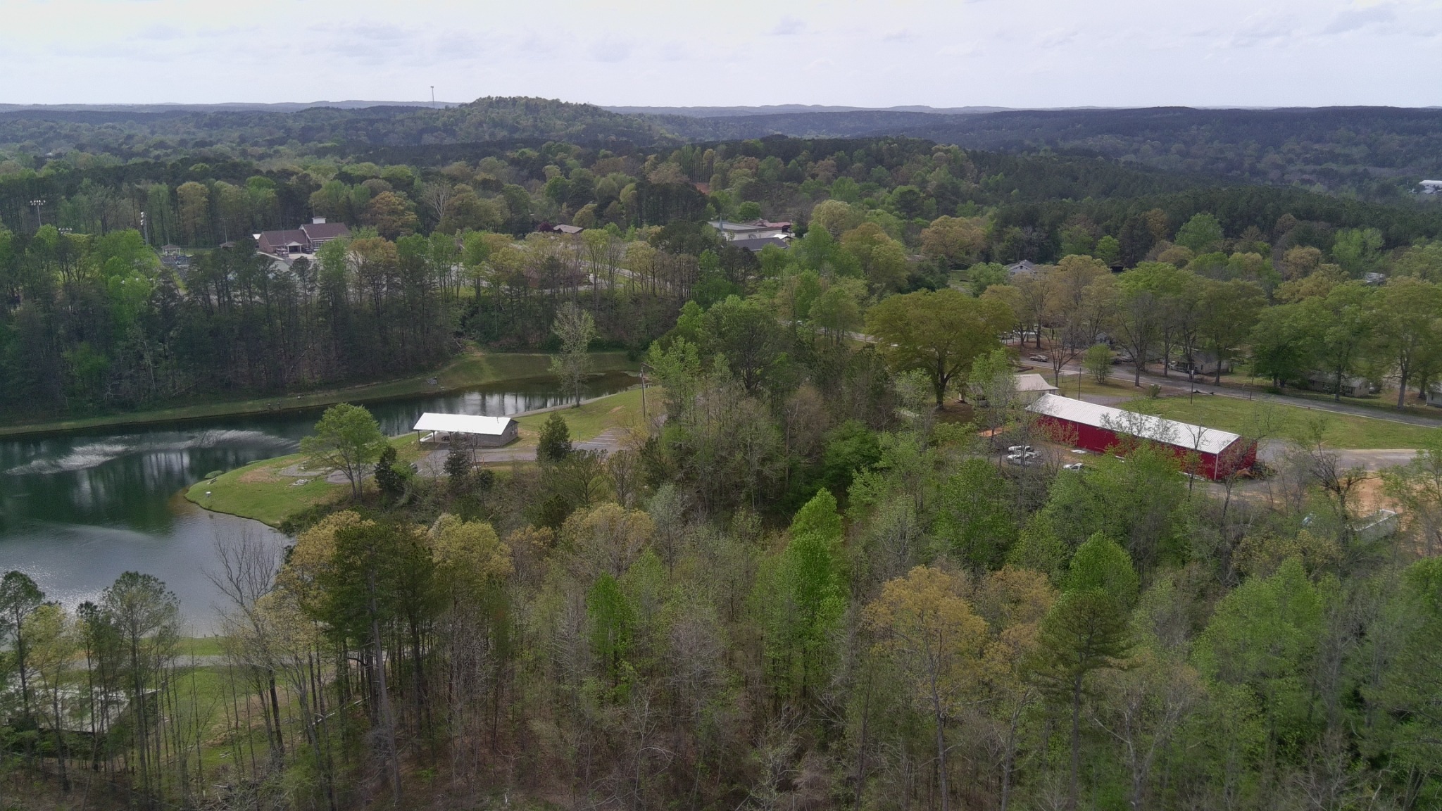 Aerial view toward nearby homes, pond, and surrounding neighborhood near Dora Municipal Park